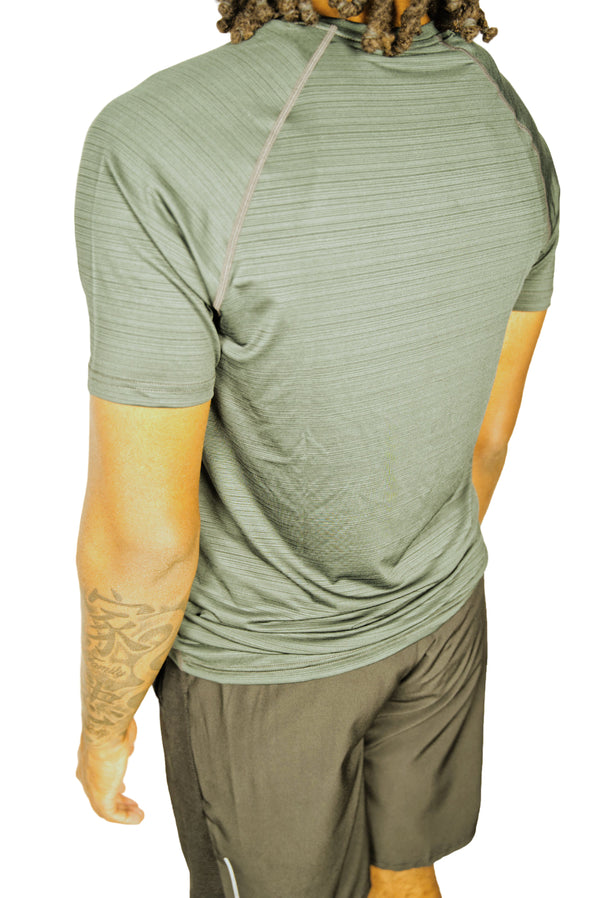 Man wearing a Forrest Green athletic Shirt with black shorts.
